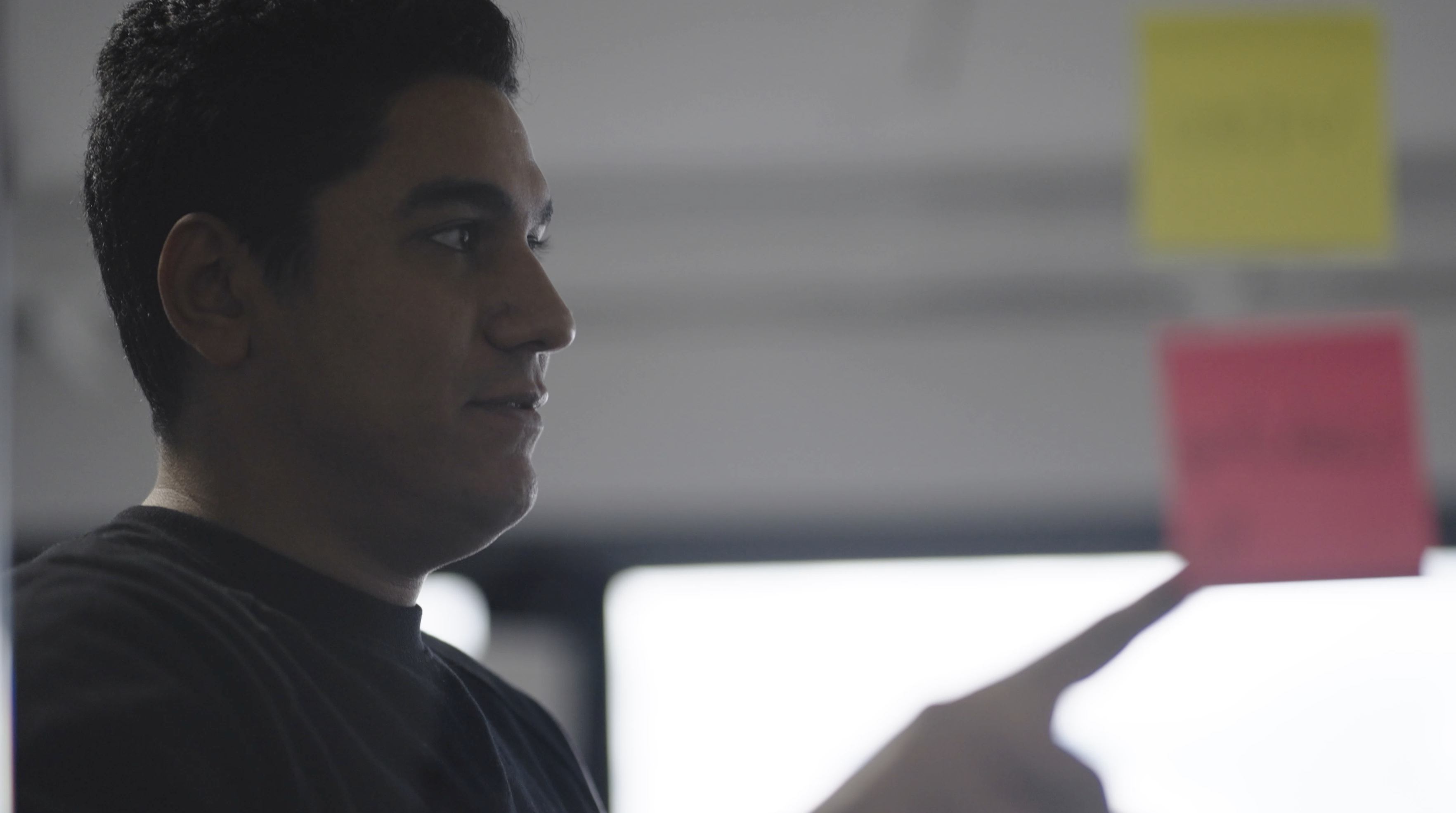 person pointing to sticky note